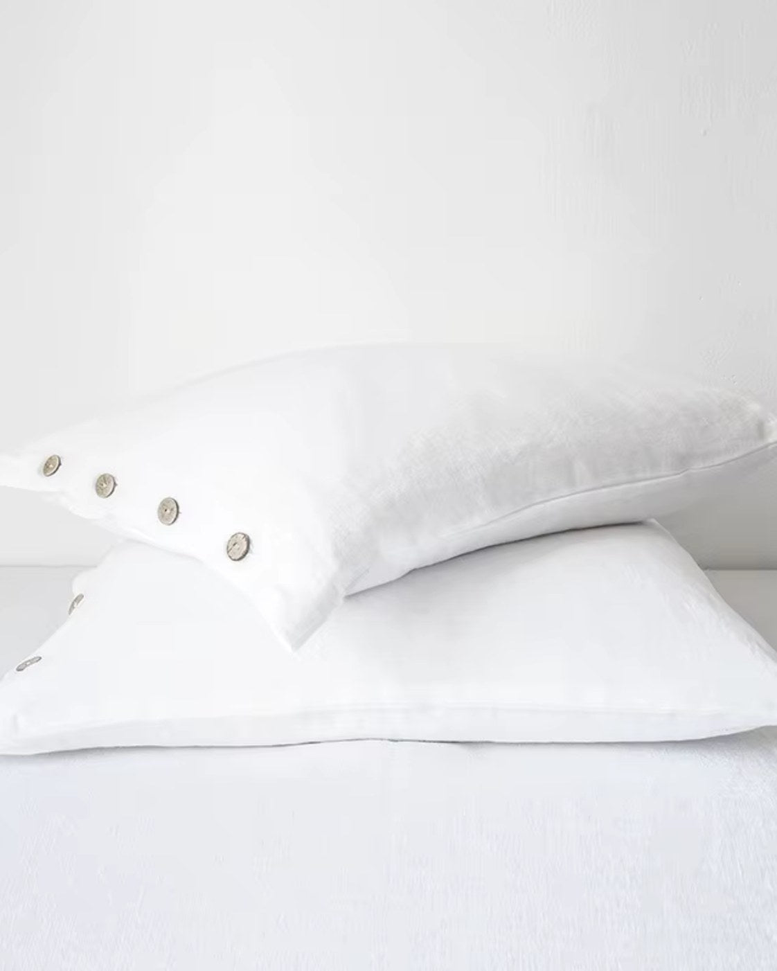 taie d'oreiller en lin pur à boutons, coloris blanc, deux oreillers empilés