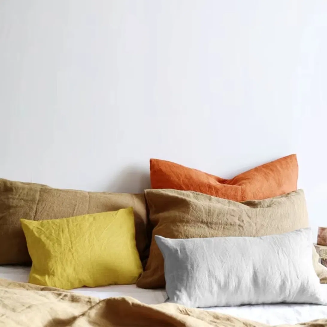 Coussins en lin lavé sur lit, ambiance chambre naturelle
